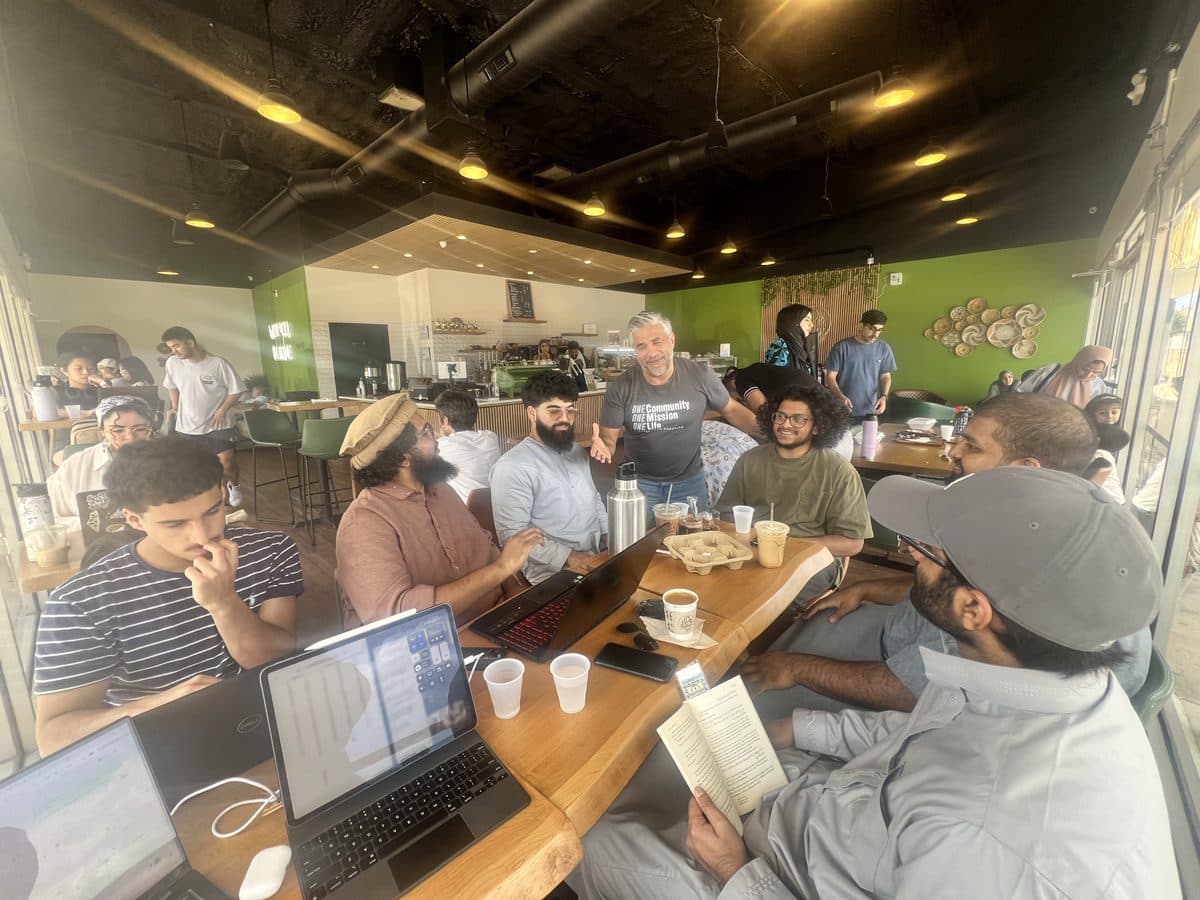 Students studying together around a long cafe table