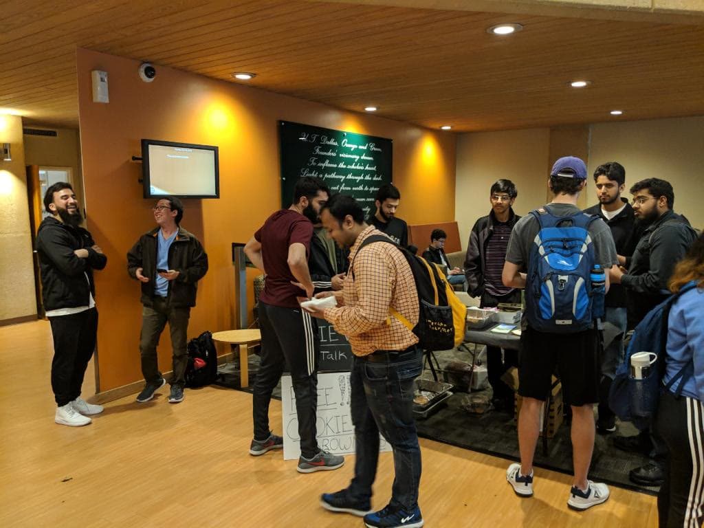 Students at a community outreach table, talking with visitors
