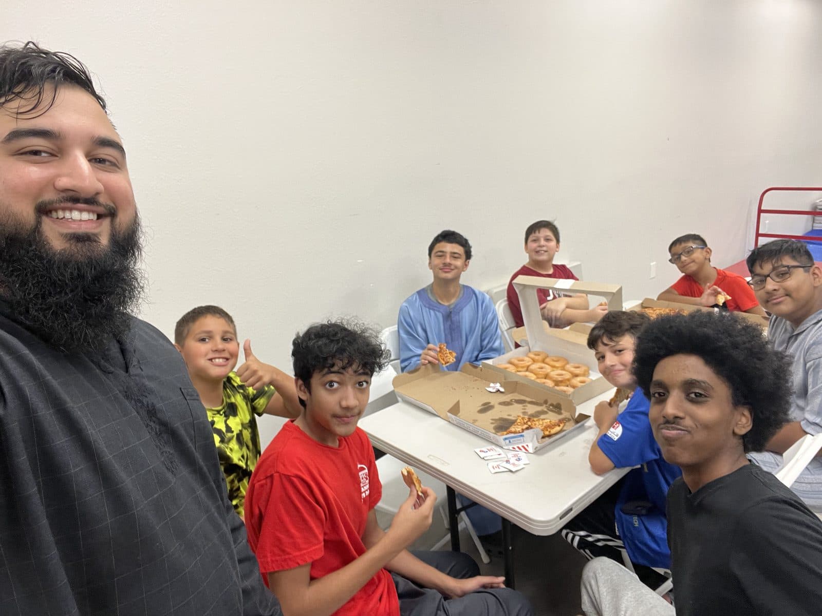 A teacher and students sharing donuts together, laughing