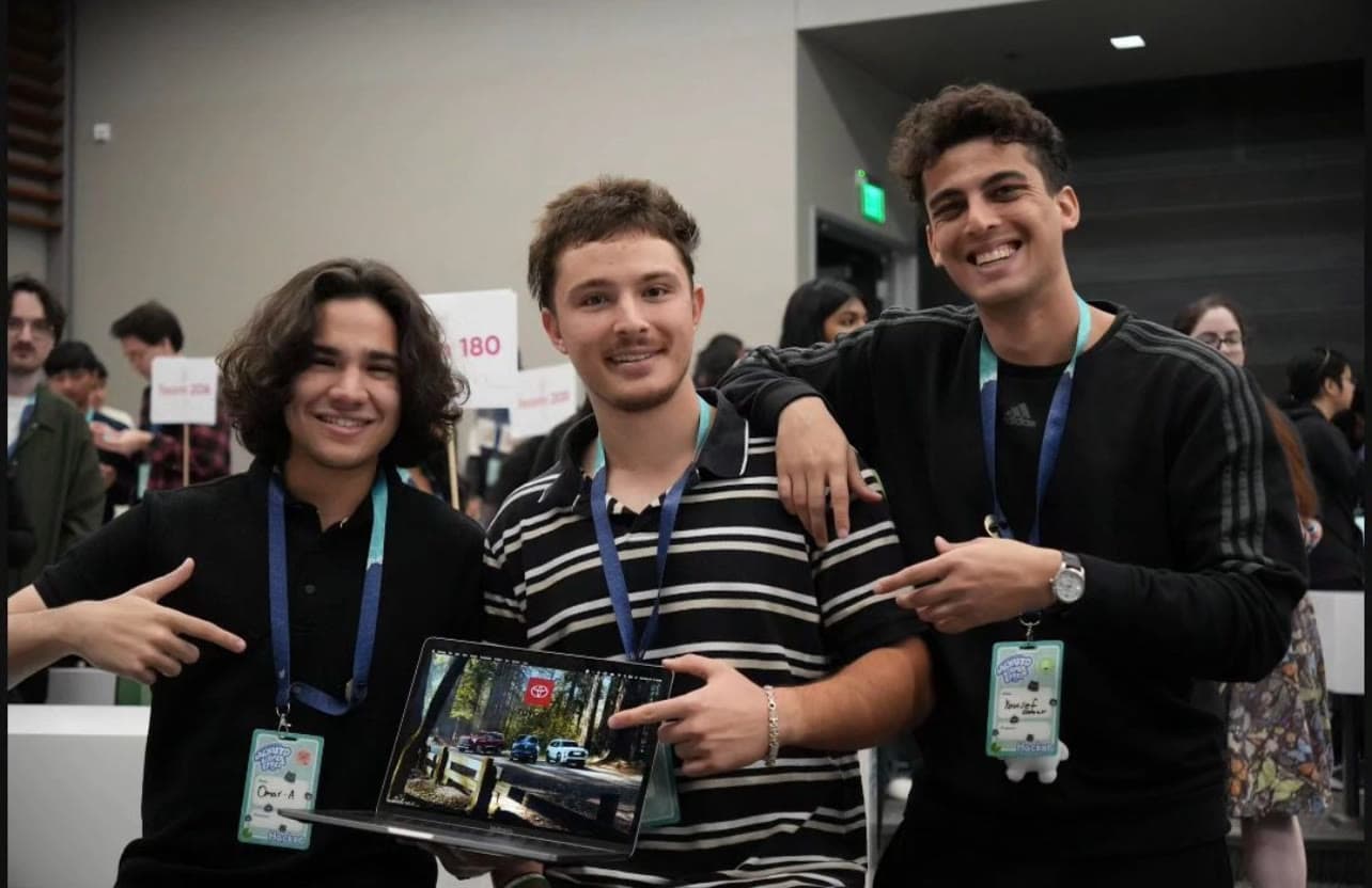 Three students smiling together at an event