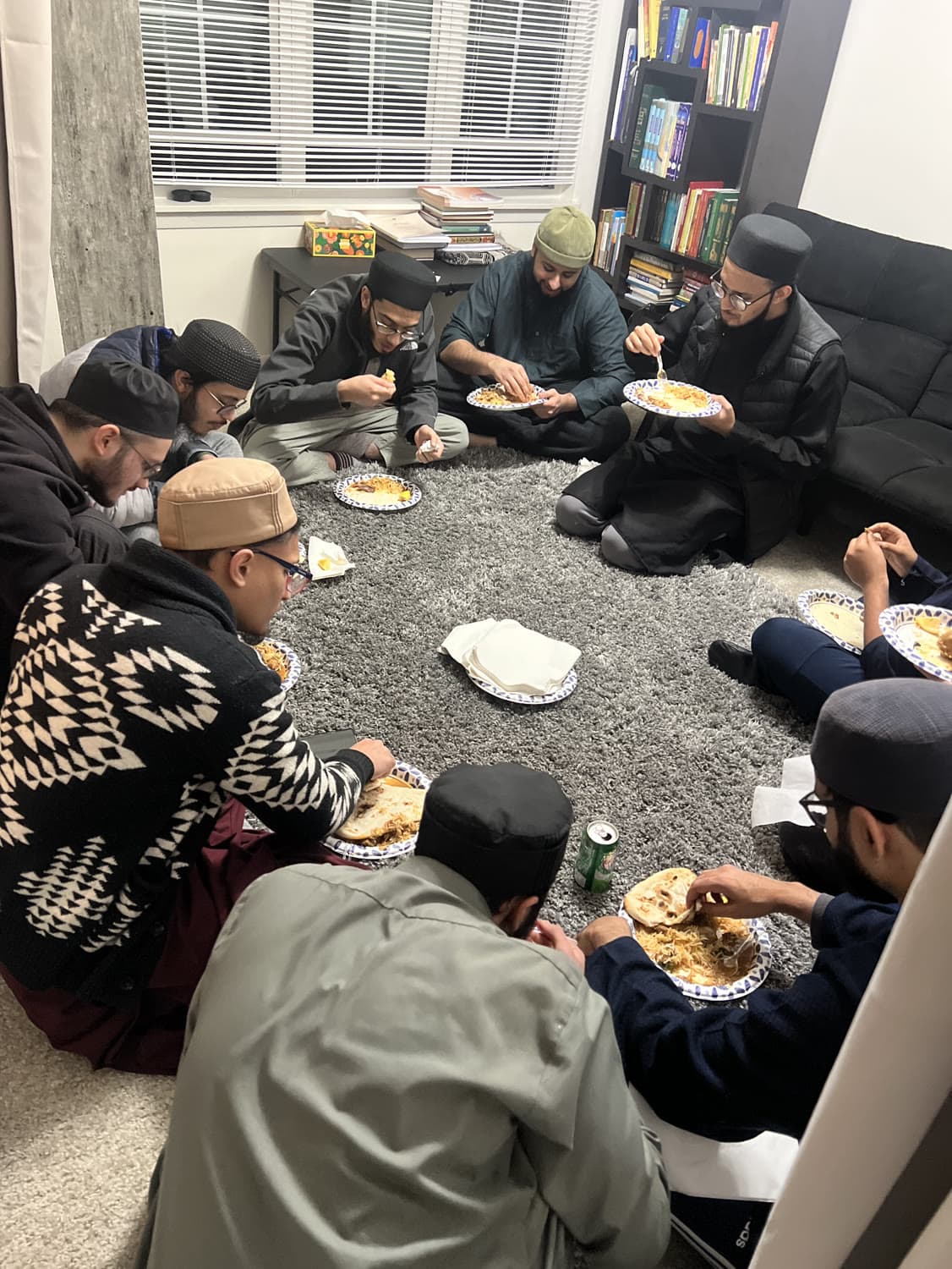 Students sharing a meal together, plates set out on the floor of a hall