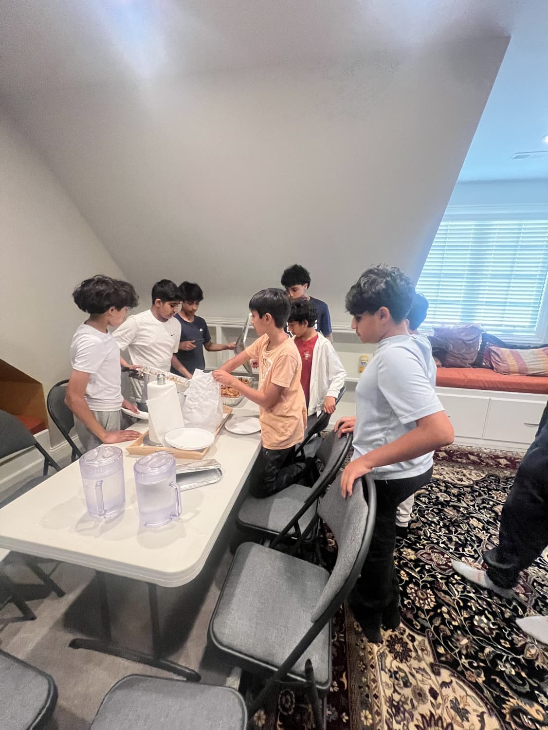 Students setting out food and supplies at a table before a gathering