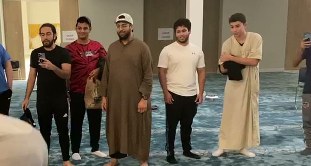 Young men standing together on the carpet of a masjid hall after fajr