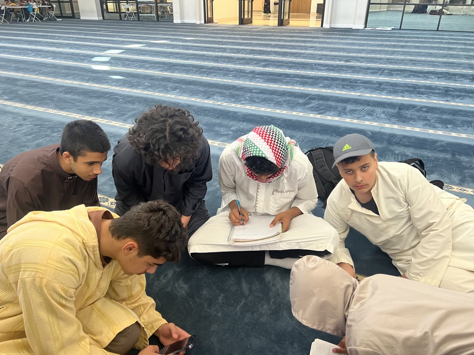 Students leaning over an open book together, working through a question