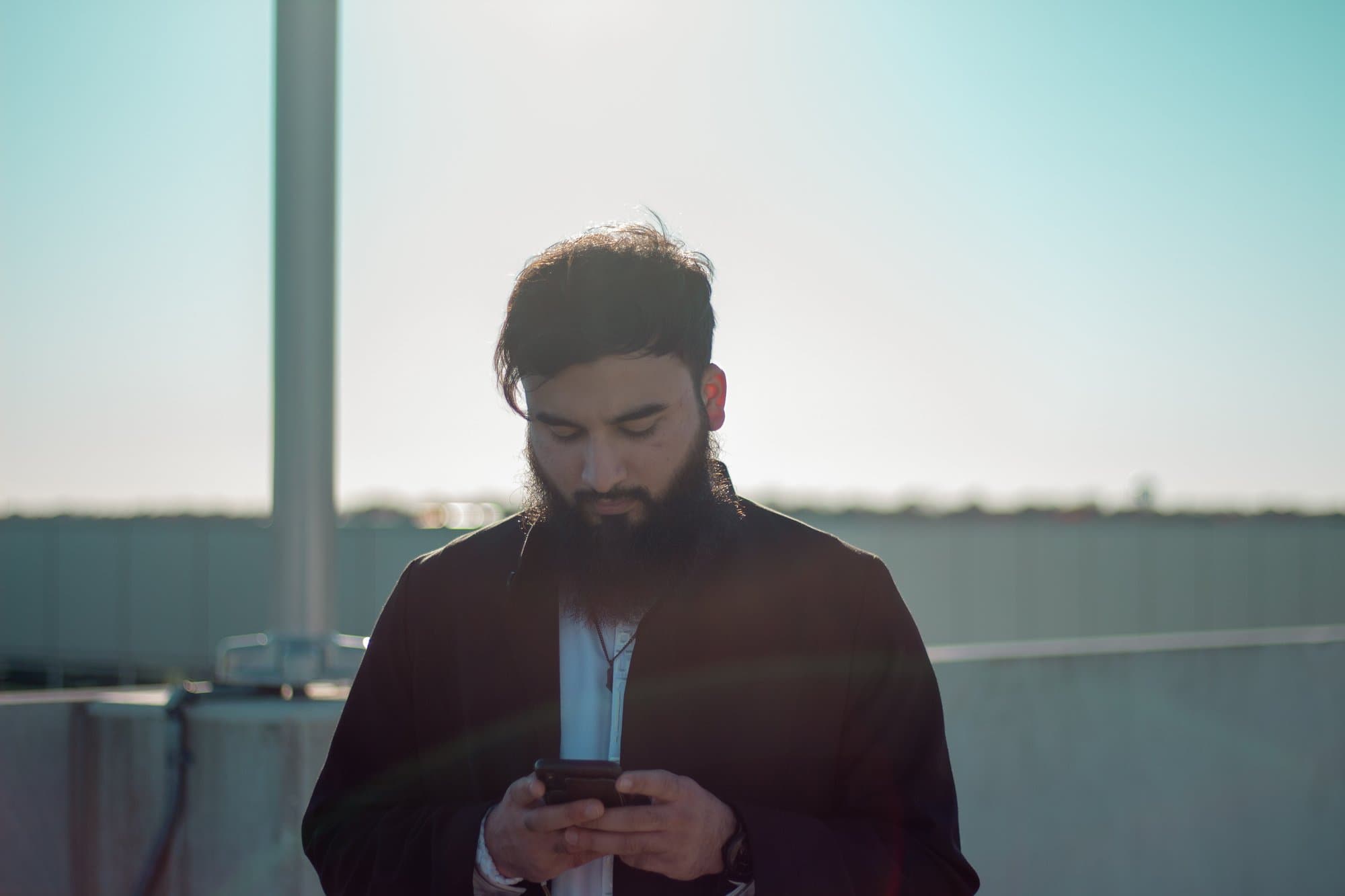 A student reading his phone outdoors in the evening light