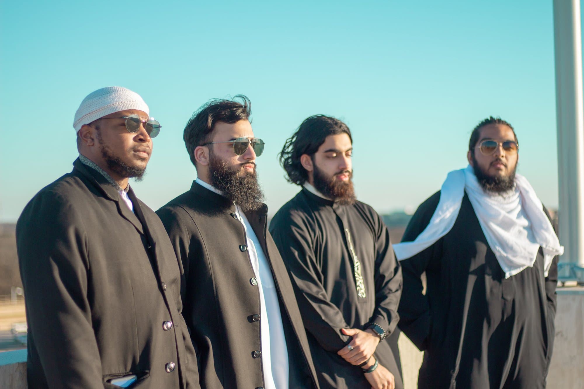 Four students standing together against a clear sky