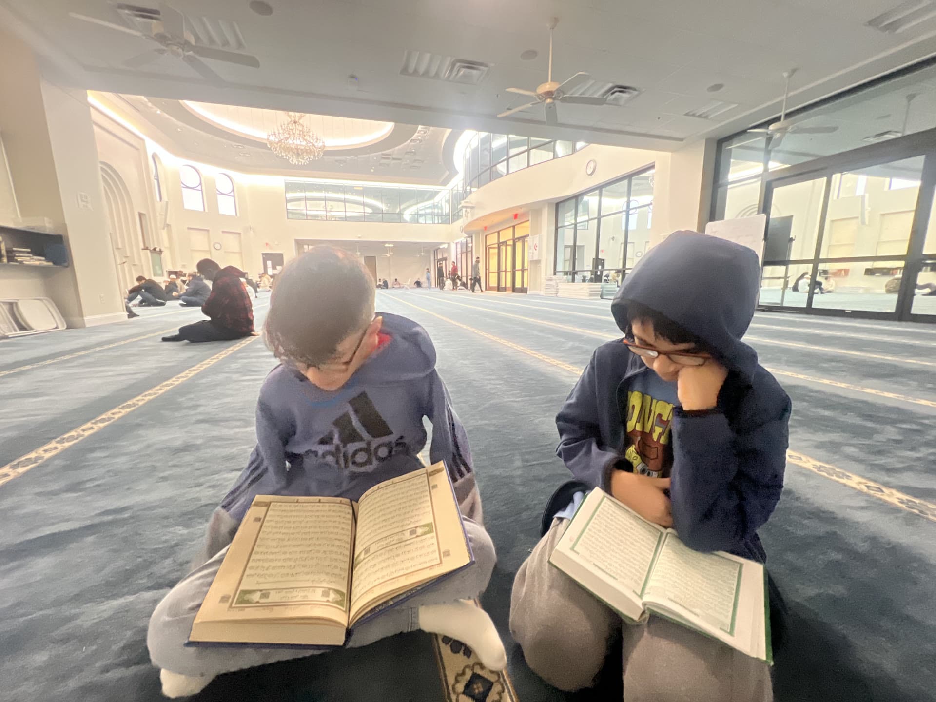 Two students reading the Qur’an together in a prayer hall
