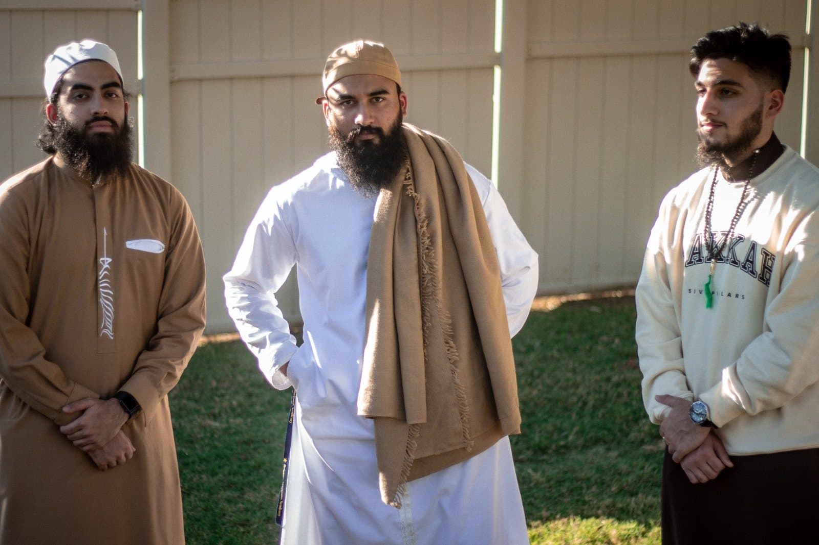 Irslan with two friends in traditional dress posing outdoors