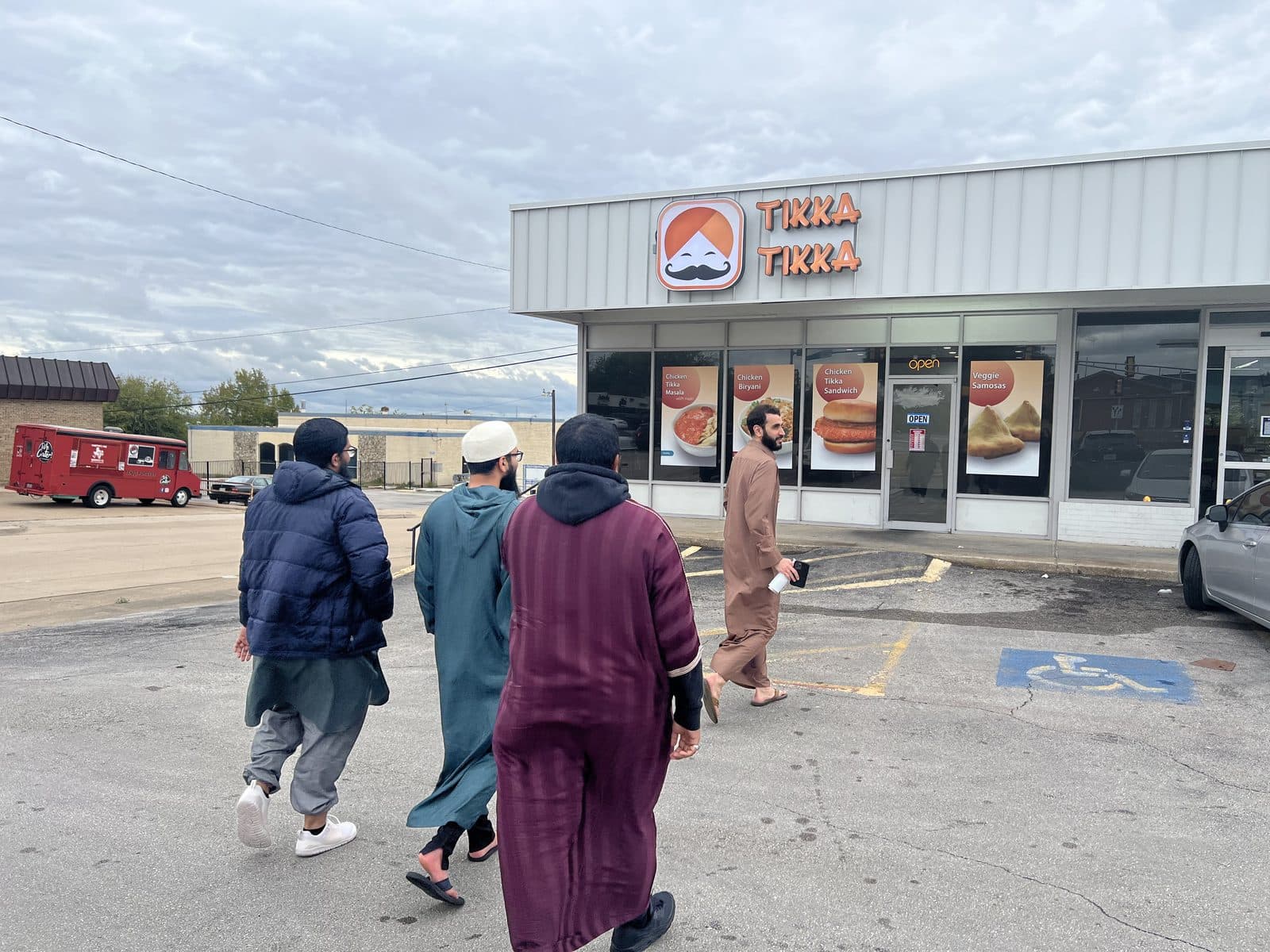 A group of young men walking together toward a restaurant